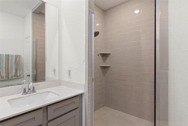 bathroom featuring a tile shower and vanity