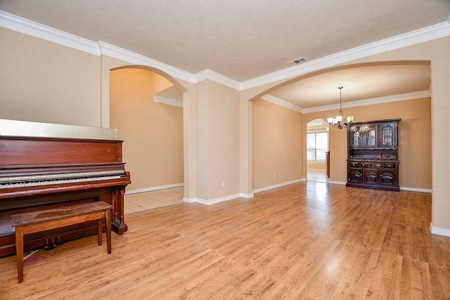 interior space with crown molding, light hardwood / wood-style flooring, and a chandelier