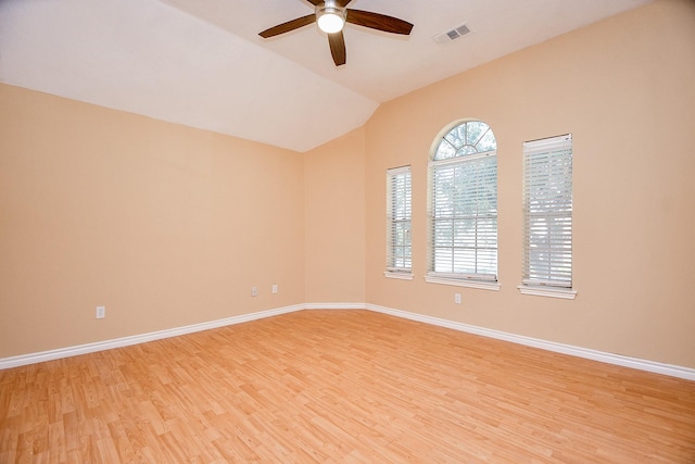 spare room featuring ceiling fan, lofted ceiling, and light wood-type flooring