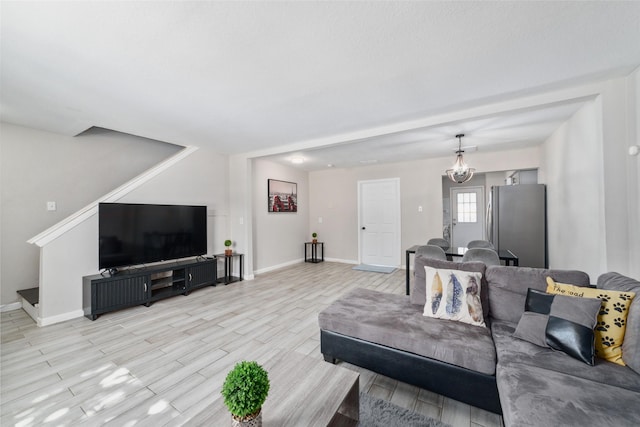 living room with a notable chandelier and light hardwood / wood-style flooring