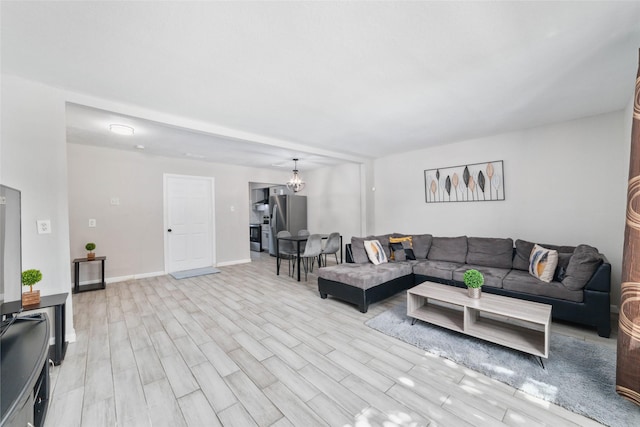 living room with a chandelier and light hardwood / wood-style floors