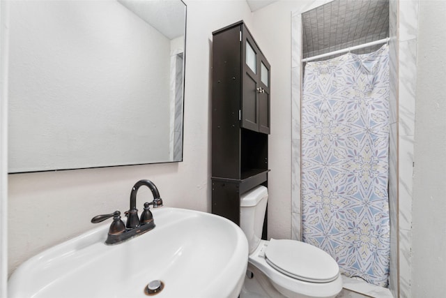 bathroom with a shower with curtain, toilet, and sink