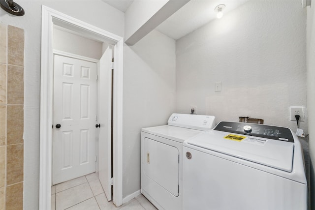 clothes washing area featuring washer and dryer and light tile patterned floors