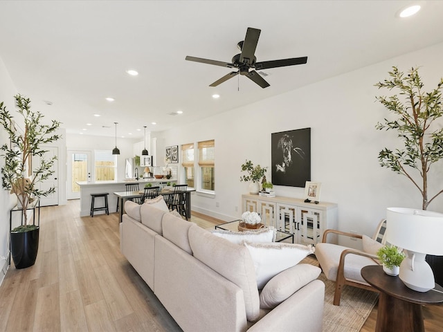 living room with light hardwood / wood-style floors and ceiling fan