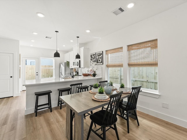 dining room with sink and light hardwood / wood-style flooring