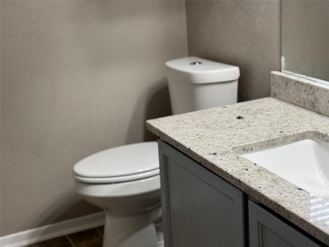 bathroom featuring tile patterned flooring, vanity, and toilet