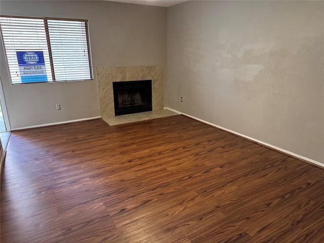 unfurnished living room featuring dark hardwood / wood-style flooring and a premium fireplace