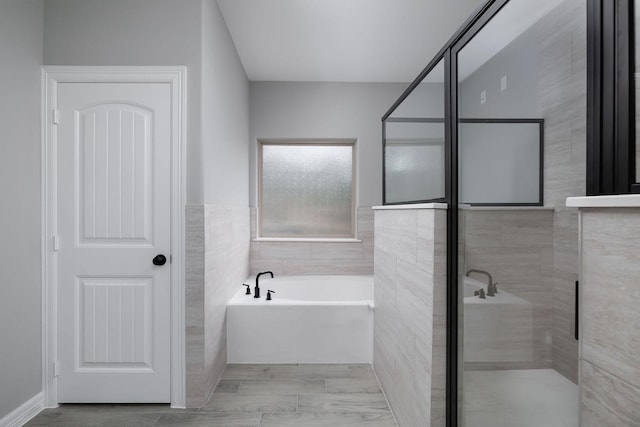 bathroom featuring separate shower and tub