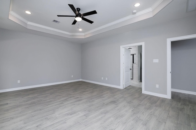 unfurnished bedroom featuring a raised ceiling, ceiling fan, light hardwood / wood-style floors, and ornamental molding