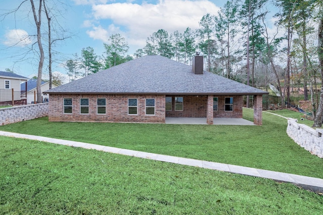 rear view of house with a lawn and a patio area