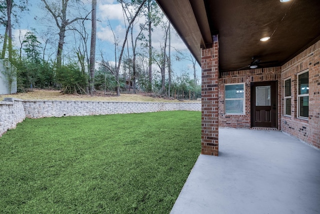 view of yard featuring ceiling fan and a patio