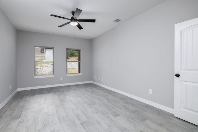 empty room with ceiling fan and light hardwood / wood-style floors