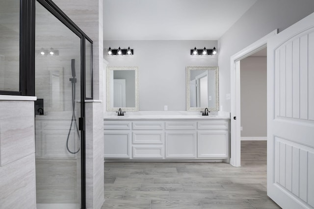 bathroom featuring vanity and a shower with door