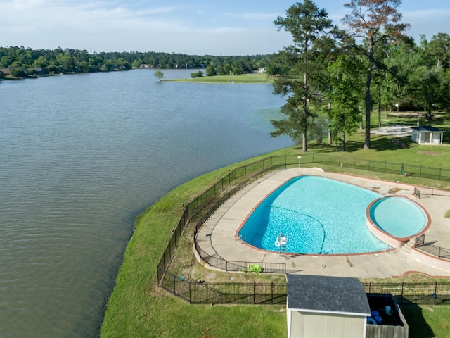 view of swimming pool featuring a lawn and a water view