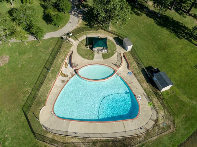 view of swimming pool with a yard