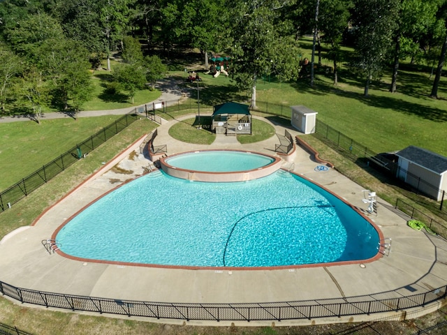 view of pool featuring a lawn, a community hot tub, and a patio