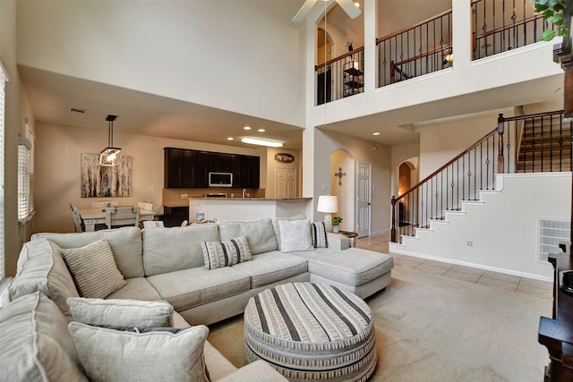 living room with light tile patterned floors and a high ceiling