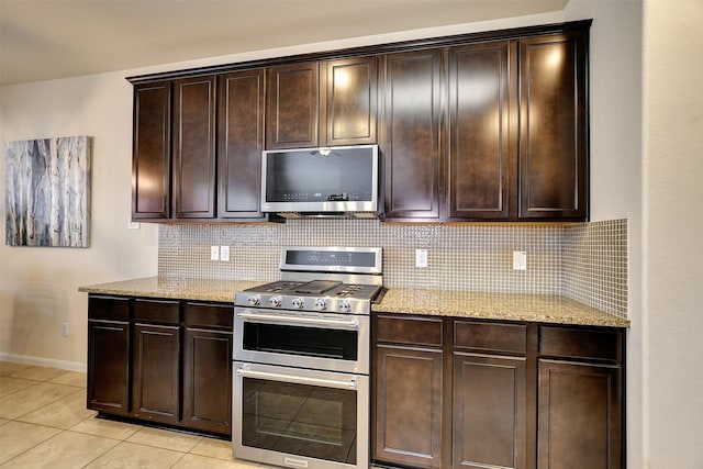 kitchen featuring backsplash, dark brown cabinets, light tile patterned floors, and stainless steel appliances