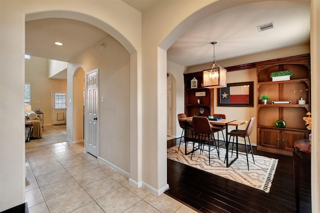 dining space featuring light tile patterned floors and an inviting chandelier