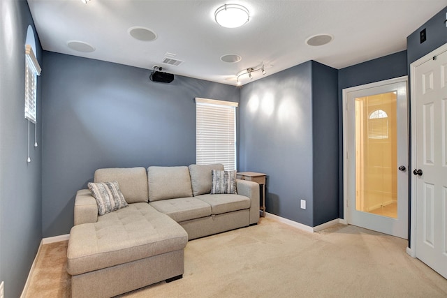 carpeted living room featuring track lighting