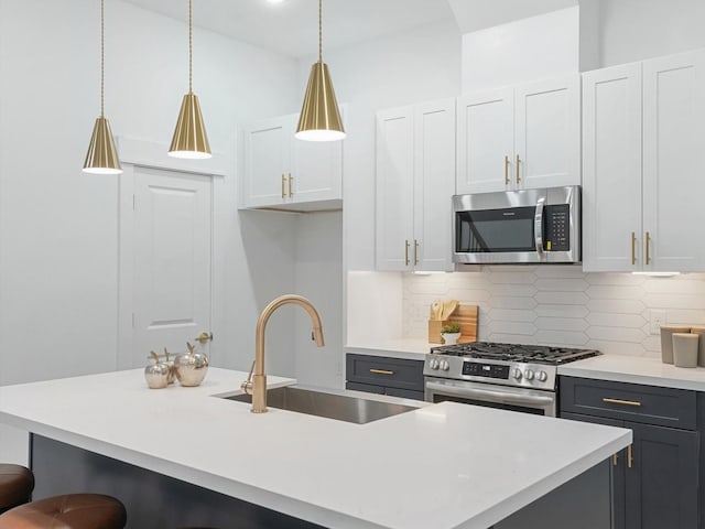 kitchen with white cabinets, pendant lighting, stainless steel appliances, and sink