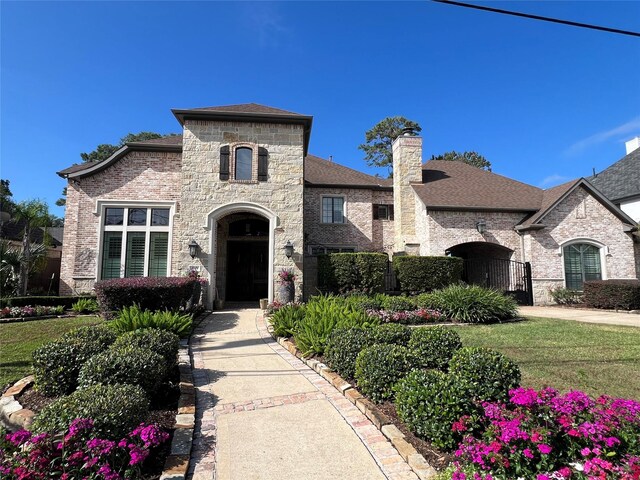 french country inspired facade with a front lawn