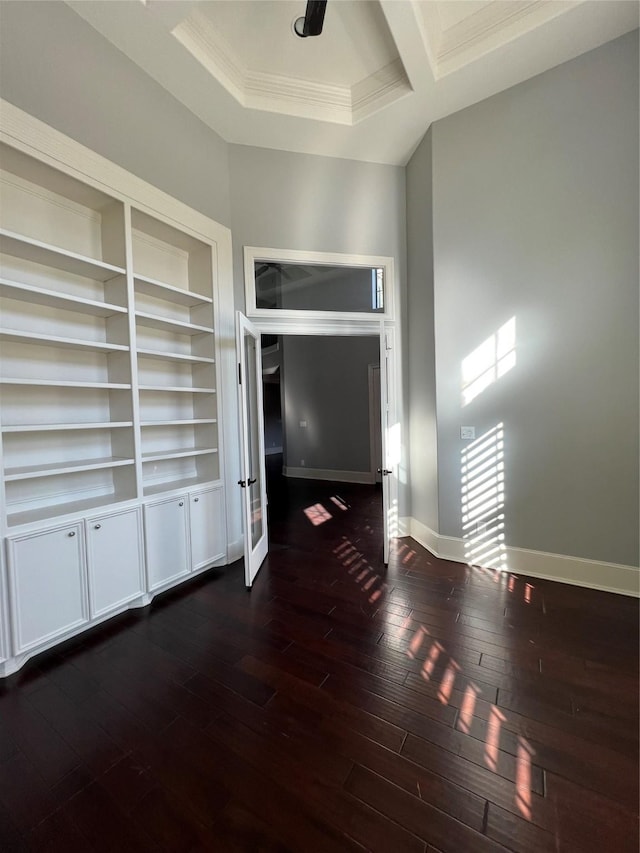 unfurnished living room featuring dark wood-type flooring and crown molding