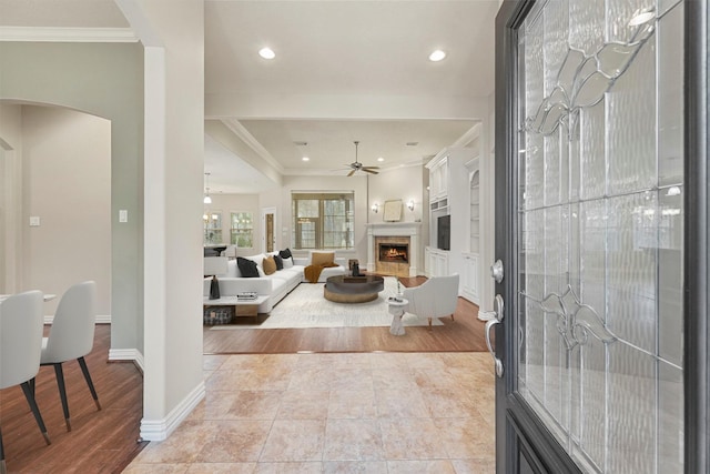 entrance foyer with ornamental molding, ceiling fan, and light tile patterned floors