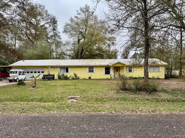 ranch-style home featuring a garage and a front lawn