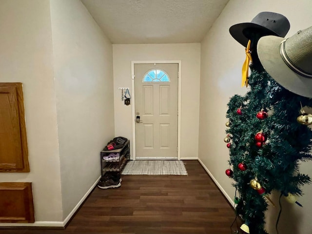 doorway with dark hardwood / wood-style flooring and a textured ceiling