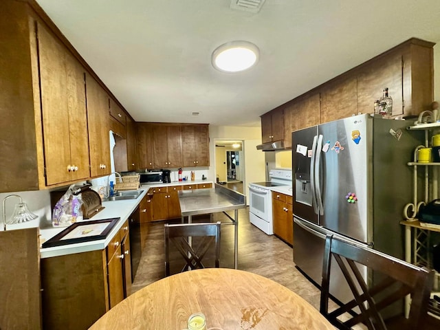 kitchen with hardwood / wood-style floors, appliances with stainless steel finishes, and sink