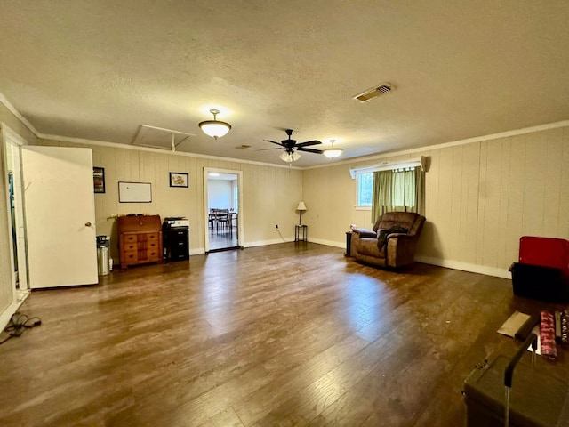 living area with dark hardwood / wood-style floors, ceiling fan, crown molding, and a textured ceiling