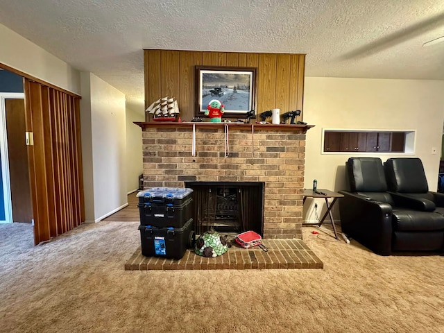 living room featuring carpet, a fireplace, and a textured ceiling