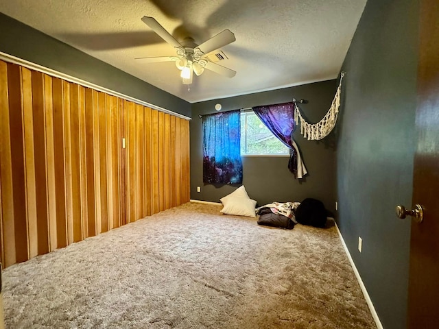 interior space with ceiling fan and a textured ceiling