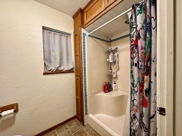 bathroom with tile patterned floors, curtained shower, and a textured ceiling