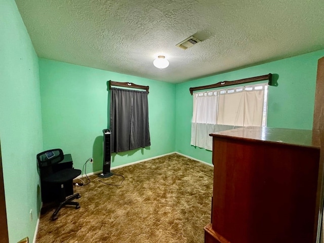 carpeted office featuring a textured ceiling