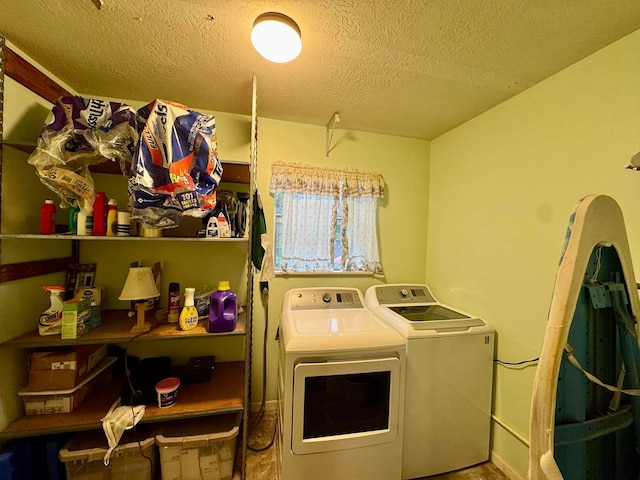 laundry room featuring washer and clothes dryer and a textured ceiling