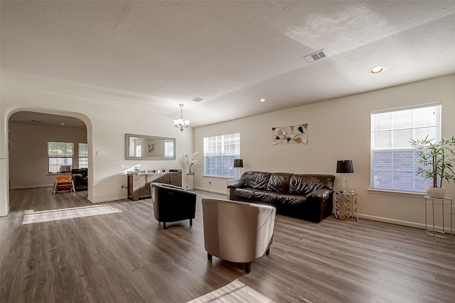 living room with hardwood / wood-style flooring, a textured ceiling, and a chandelier