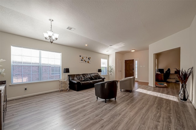 living room featuring a chandelier, a textured ceiling, and hardwood / wood-style flooring