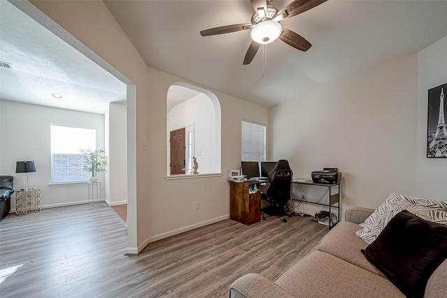 home office with light hardwood / wood-style floors and ceiling fan