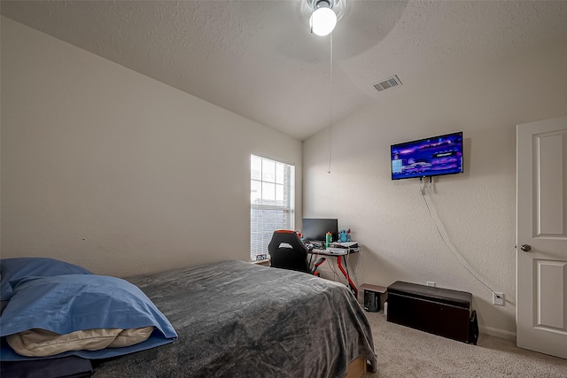 carpeted bedroom featuring ceiling fan, lofted ceiling, and a textured ceiling