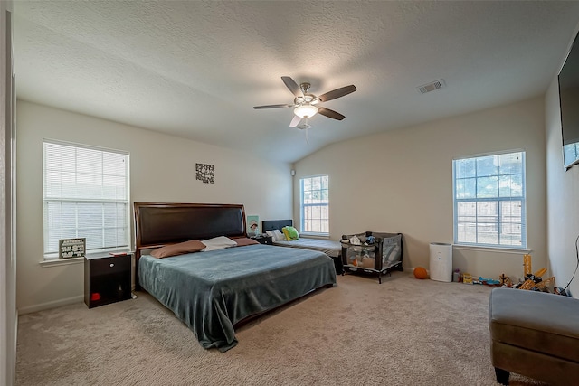 bedroom with a textured ceiling, ceiling fan, light carpet, and vaulted ceiling