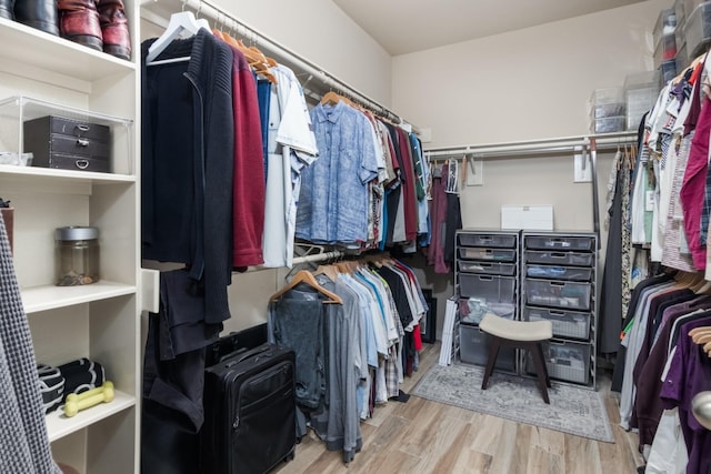 walk in closet with light hardwood / wood-style floors