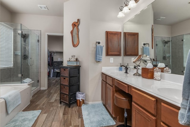 bathroom with wood-type flooring, vanity, and shower with separate bathtub