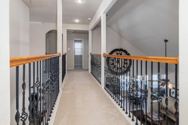 corridor featuring carpet and lofted ceiling