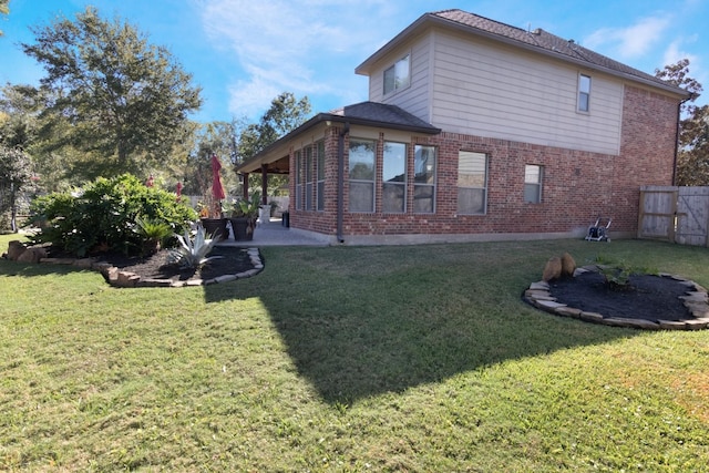 back of house featuring a lawn and a patio area