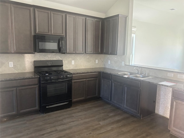 kitchen featuring lofted ceiling, black appliances, sink, dark hardwood / wood-style floors, and stone countertops