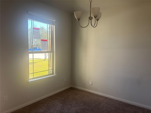 empty room with carpet and a chandelier