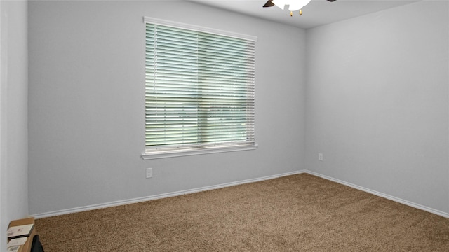 carpeted spare room featuring ceiling fan