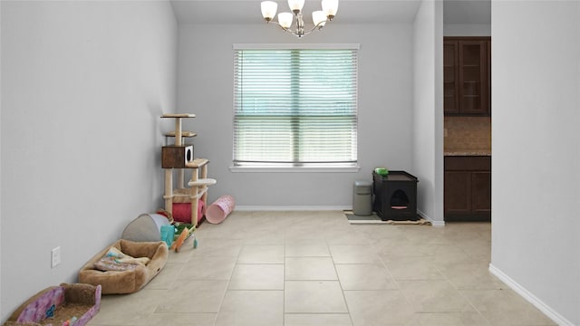 recreation room with light tile patterned floors, a wealth of natural light, and a chandelier